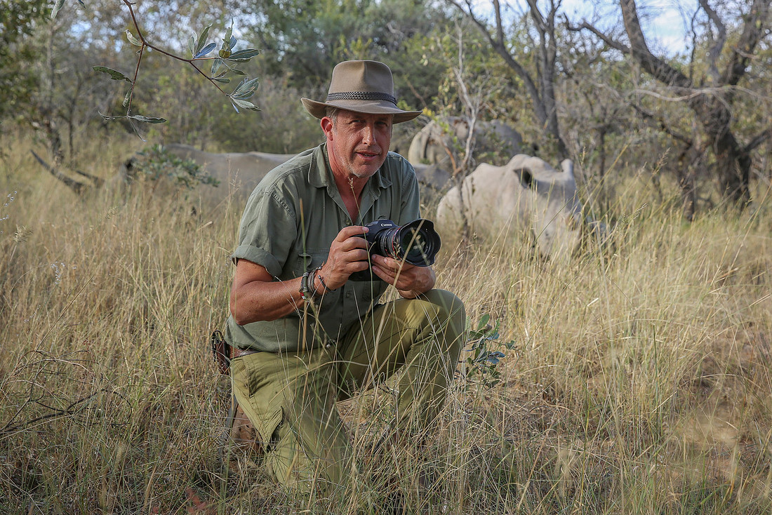 Andrew Yates photographing rhino at close range in the African bush